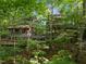 Expansive exterior of a multi-level home with large windows, multiple decks, and lush greenery at 106 Mill Rock Ct, Carrboro, NC 27510