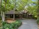 Captivating exterior showcasing a spacious carport, gravel driveway, and picturesque natural landscaping at 106 Mill Rock Ct, Carrboro, NC 27510