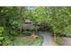 Aerial view of a gray home surrounded by lush greenery, beautiful landscaping, and a charming driveway at 106 Mill Rock Ct, Carrboro, NC 27510