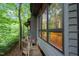 Exterior of a home with a wooden walkway, large windows, and natural surroundings at 106 Mill Rock Ct, Carrboro, NC 27510