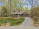 Charming front exterior featuring mature trees, lush landscaping, and a private driveway at 106 Mill Rock Ct, Carrboro, NC 27510