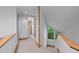 Bright hallway with carpet, wood handrail, and door leading to the en-suite bathroom at 106 Mill Rock Ct, Carrboro, NC 27510