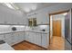 Well-lit kitchen with white cabinets, sleek appliances, and a window with wooded views at 106 Mill Rock Ct, Carrboro, NC 27510