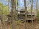 Rear view of the home with multilevel decks and a wooded setting at 106 Mill Rock Ct, Carrboro, NC 27510