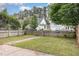 View of a backyard with a grass lawn, wooden fence, and a brick walkway in a suburban setting at 10744 Cokesbury Ln, Raleigh, NC 27614
