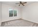 Spacious bedroom with ceiling fan, neutral walls, and a large window looking out to foliage at 10744 Cokesbury Ln, Raleigh, NC 27614