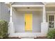 Inviting front porch with a striking yellow door and white columns enhance the curb appeal at 10744 Cokesbury Ln, Raleigh, NC 27614