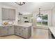 Bright and airy kitchen offers a modern aesthetic with gray cabinets, light countertops, and open layout at 10744 Cokesbury Ln, Raleigh, NC 27614