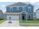 Charming two-story home featuring blue siding, brick accents, a two-car garage, and a well-maintained front lawn at 1108 Landen Creek Ln, Zebulon, NC 27597
