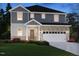 Two-story home showcasing a brick and gray facade, a two-car garage, and a well-manicured lawn at dusk at 1108 Landen Creek Ln, Zebulon, NC 27597