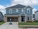 Two-story home with a two car garage, blue siding, brick accents, and well-manicured lawn at 1108 Landen Creek Ln, Zebulon, NC 27597