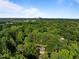An aerial view of a home and surrounding lush greenery with the city skyline in the distance at 1112 Blenheim Dr, Raleigh, NC 27612