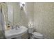 Charming powder room featuring designer wallpaper and pedestal sink at 1112 Blenheim Dr, Raleigh, NC 27612