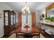 Formal dining room with french doors, elegant chandelier, and china cabinet at 1112 Blenheim Dr, Raleigh, NC 27612