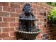 Ornate lion head fountain mounted on a brick wall with cascading water at 1112 Blenheim Dr, Raleigh, NC 27612