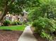 Serene walkway leading to a red brick home surrounded by mature landscaping at 1112 Blenheim Dr, Raleigh, NC 27612