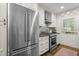 Bright kitchen featuring stainless steel appliances, white cabinetry and hardwood floors at 1112 Blenheim Dr, Raleigh, NC 27612