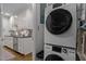 Modern laundry area with stacked washer and dryer and a kitchen view at 1112 Blenheim Dr, Raleigh, NC 27612
