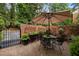 Brick patio provides a cozy outdoor dining area with brick privacy wall and lush landscaping at 1112 Blenheim Dr, Raleigh, NC 27612
