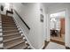Carpeted staircase with dark wood trim and a dining room at the top of the stairs at 1112 Blenheim Dr, Raleigh, NC 27612