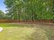 Large backyard featuring a spacious grassy area and wooded border at 1148 Tringham Ct, Apex, NC 27502