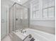 Bright bathroom featuring a glass-enclosed shower, tub, and white tile at 1148 Tringham Ct, Apex, NC 27502
