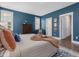 Bedroom featuring blue walls, neutral-toned bed and bedding, and wood flooring at 1148 Tringham Ct, Apex, NC 27502