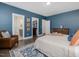 Bedroom featuring a large bed, blue walls, and three interior door ways at 1148 Tringham Ct, Apex, NC 27502