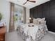 Bedroom featuring dark wood wall, tan carpet, decorative curtains, and natural light at 1148 Tringham Ct, Apex, NC 27502