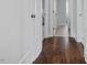 Hallway with dark wood floors, white trim, and neutral walls at 1148 Tringham Ct, Apex, NC 27502