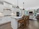 Bright kitchen features white cabinets, stainless steel appliances, and an island with bar seating at 1148 Tringham Ct, Apex, NC 27502