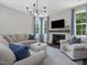 Bright living room featuring lots of windows, fireplace, TV, and cozy seating at 1148 Tringham Ct, Apex, NC 27502