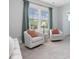 Bright sitting area features two chairs with natural light from large windows at 1148 Tringham Ct, Apex, NC 27502