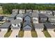 Aerial view of new construction neighborhood with tree line, showing the layout and spacing of homes and garages at 117 Banning Dr, Pittsboro, NC 27312