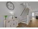 Bright entryway with hardwood floors, a staircase, and a decorative clock above the console table at 117 Banning Dr, Pittsboro, NC 27312