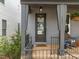Covered front porch with hanging plants, view of front door with sidelight and transom window at 117 Banning Dr, Pittsboro, NC 27312