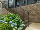 Close-up on the brick stairs leading to the covered porch and garden with blue hydrangea bushes at 117 Banning Dr, Pittsboro, NC 27312