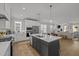 Bright kitchen with white cabinets, stainless steel appliances, a large island, and an open layout to living room at 117 Banning Dr, Pittsboro, NC 27312