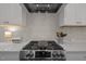 Close-up of a modern kitchen featuring a gas range with stainless steel appliances and a decorative backsplash at 117 Banning Dr, Pittsboro, NC 27312