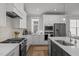Bright kitchen with white cabinets, stainless steel appliances, designer backsplash, and a gas range at 117 Banning Dr, Pittsboro, NC 27312