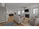Open-concept living room with hardwood floors, fireplace, and seamless access to the modern kitchen at 117 Banning Dr, Pittsboro, NC 27312