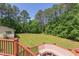 Expansive backyard view from deck showcases manicured lawn surrounded by mature trees at 117 Carolina Forest Rd, Chapel Hill, NC 27516
