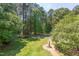 Large backyard with brick paver walkway and mature trees create a relaxing oasis at 117 Carolina Forest Rd, Chapel Hill, NC 27516