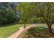 Expansive backyard with brick pathway, mature trees, and landscaped areas, perfect for outdoor enjoyment at 117 Carolina Forest Rd, Chapel Hill, NC 27516