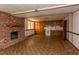 Spacious basement area with a brick fireplace, vintage style flooring, and wooden cabinets at 117 Carolina Forest Rd, Chapel Hill, NC 27516