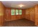 Basement room with wood paneling and vintage style flooring with a view to the exterior at 117 Carolina Forest Rd, Chapel Hill, NC 27516