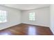 Bright bedroom with two windows and hardwood flooring provides natural light at 117 Carolina Forest Rd, Chapel Hill, NC 27516