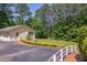 Exterior view of a two-car garage, long driveway, and lush landscaping in a tranquil setting at 117 Carolina Forest Rd, Chapel Hill, NC 27516