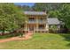 Charming yellow two-story home with a covered porch and landscaped lawn at 117 Carolina Forest Rd, Chapel Hill, NC 27516