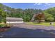 Detached two-car garage alongside a large yard with mature trees and landscaping at 117 Carolina Forest Rd, Chapel Hill, NC 27516
